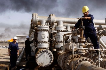 image: Iraqi workers are seen at the Rumaila oil refinery, near the city of Basra, southeast of Baghdad, Iraq, Dec. 13, 2009.