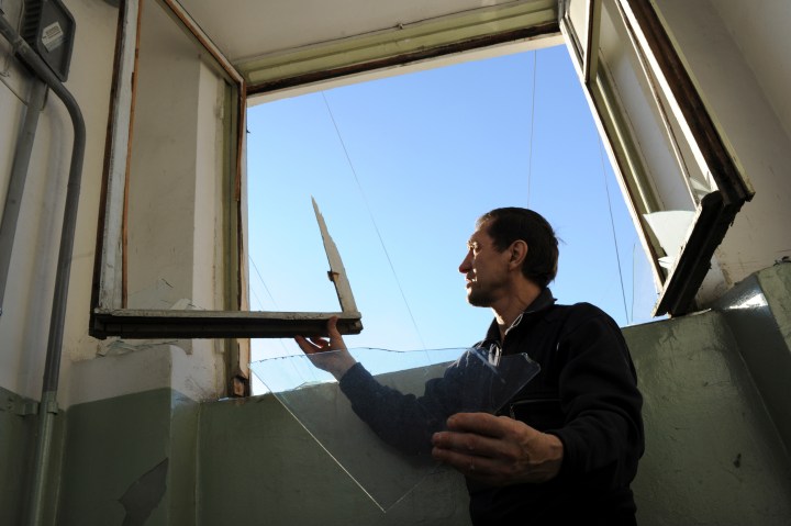 A local resident repairs a window broken by a shock wave from a meteor explosion in Chelyabinsk, Russia.