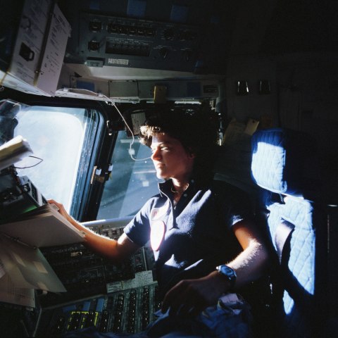 NASA Astronaut Sally K. Ride, STS-7 mission specialist, communicates with ground controllers from the flight deck of the Earth-orbiting Space Shuttle Challenger at an unknown location, on June 21, 1983.