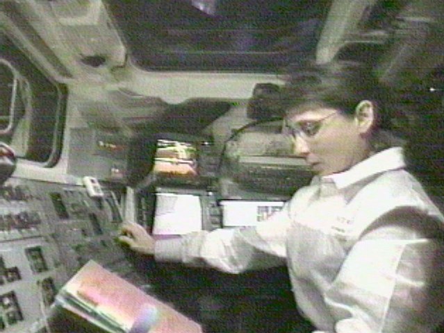 NASA Astronaut Nancy Currie reads a manual as she grapples the Unity module in the cargo bay of the Endeavour, on Dec. 6, 1998.