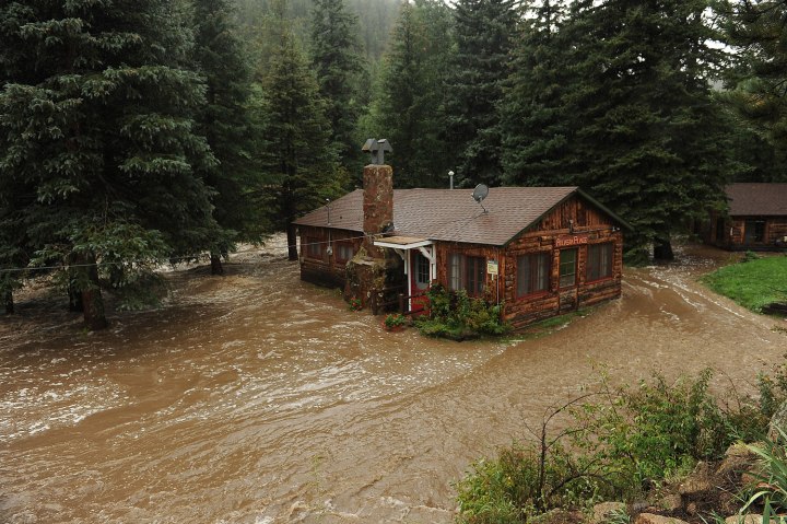 A house owned by longtime resident Gale Erlewine sits submerged in the South St. Vrain river that was consumed by flooding near the roadside community of Riverside, about 12 miles west of Lyons, Colo. along Highway 7, on Sept.12, 2013.