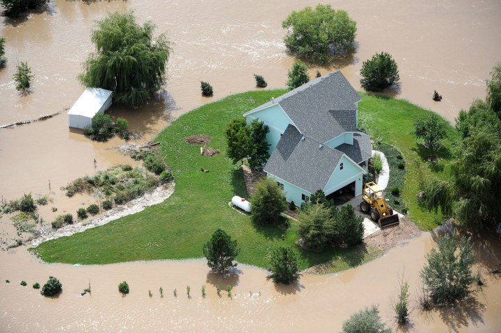 A home near Evans, Colo., is surrounded by flood waters from the South Platte River, on Sept. 16, 2013.