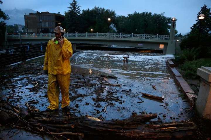 A city worker talks on his phone while surveying high water levels on Boulder Creek following overnight flash flooding in downtown Boulder, Colo., on Sept. 12, 2013.