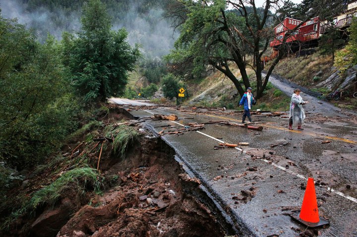 Colorado FloBrother and sister Patrick Tinsley and Mary Kerns walk into Boulder, Colo., from their mountain community Magnolia, where road access is shut off by debris from days of record rain and flooding, at the base of Boulder Canyon, Colo., on Sept. 13, 2013.oding
