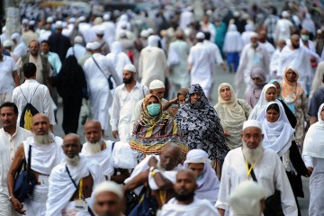 A Muslim pilgrim wears a mask as she walks to Mecca's Grand Mosque to perform evening prayers on October 8, 2013 prior to the start of the annual hajj pilgrimage which begins on October 13.