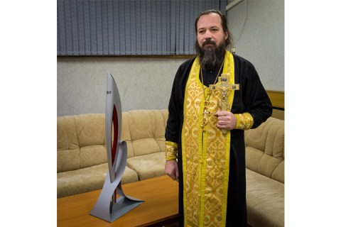 Orthodox priest, Father Sergei, with the 2014 Sochi Olympic torch before it launched with Expedition 38 Soyuz Commander Mikhail Tyurin of Roscosmos, Flight Engineer Koichi Wakata of the Japan Aerospace Exploration Agency, and, Flight Engineer Rick Mastracchio of NASA, on Nov. 7, 2013, in Baikonur, Kazakhstan.