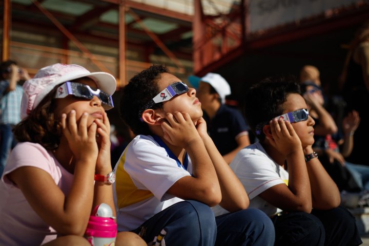 Children wearing solar protective glasses observe the partial solar eclipse in Tunisia, on Nov. 3, 2013.