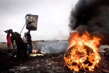 A boy places another piece of 'e-waste' on a burning pile of electronics in Agbogbloshie, Accra, Ghana, in 2008.