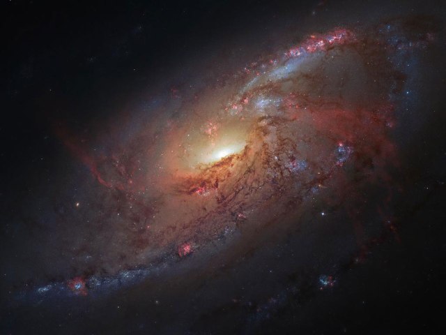This image combines Hubble observations of the M 106 galaxy with additional information captured by amateur astronomers Robert Gendler and Jay GaBany.