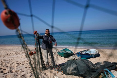 Palestinian fisherman Joudat Ghrab, who said he scooped a 500-kg bronze statue of the Greek God Apollo from the sea bed last August, prepares his fishing net in the central Gaza Strip